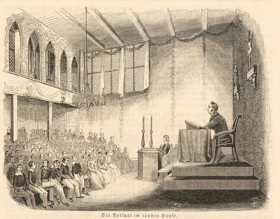A nineteenth-century wood engraving of a long hall with rows of benches, where children and teachers sit for prayers.