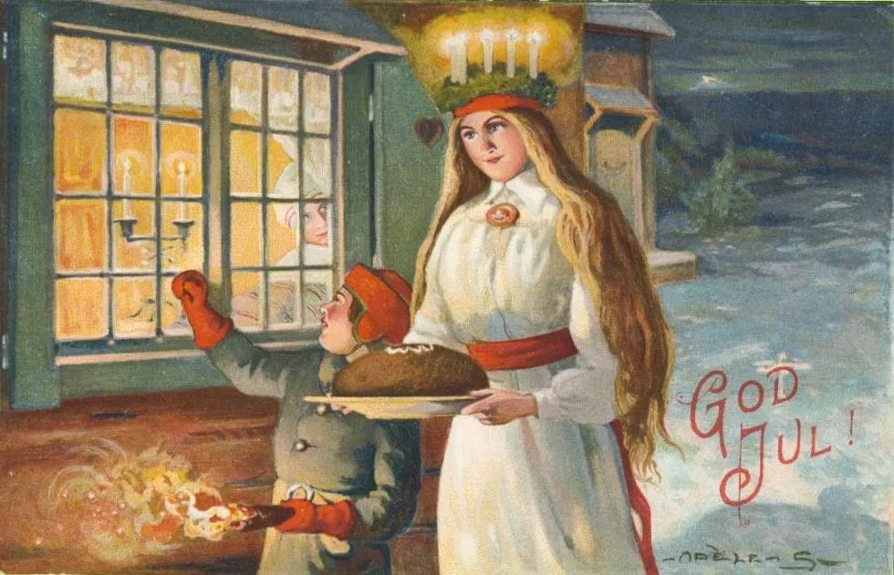 A girl in a white gown with a crown of four candles carries a round loaf on a plate past a lit window. A boy in a red cap holds a torch. Red letters say God Jul.